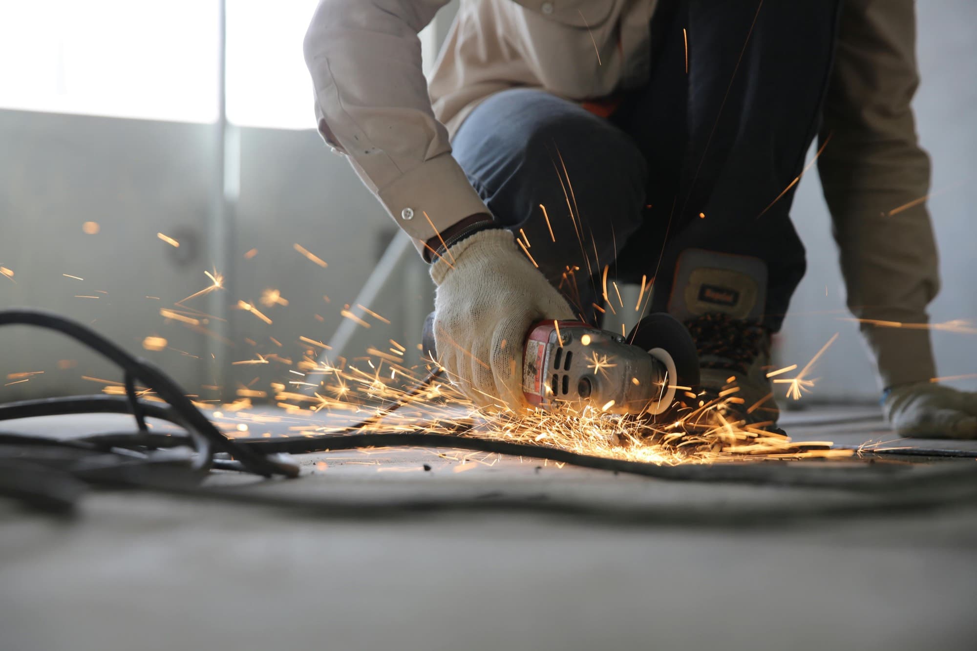 Grinding steel on a commercial job site, sparks across a concrete floor