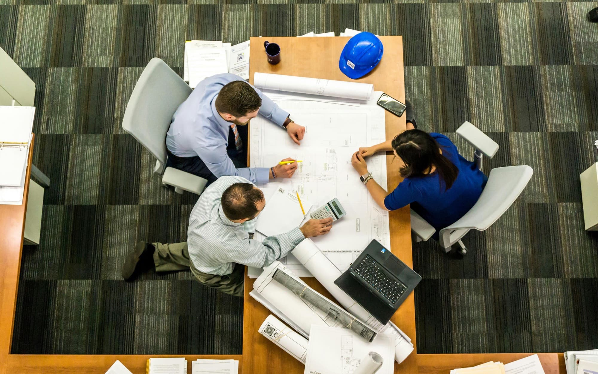 Project team reviewing construction drawings at a table
